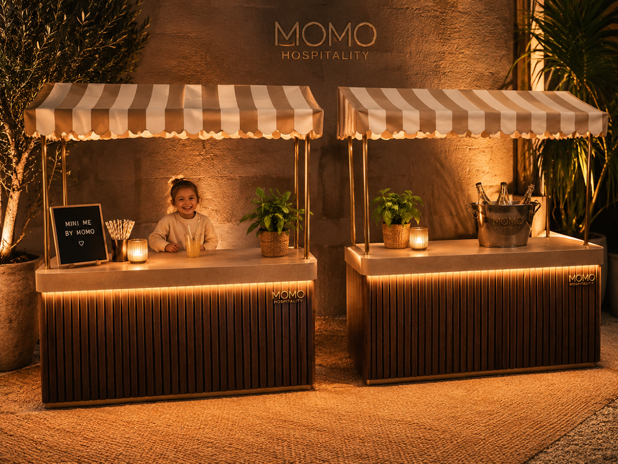 Two elegant MOMO Mini Me bars with striped awnings in a warm hospitality setting